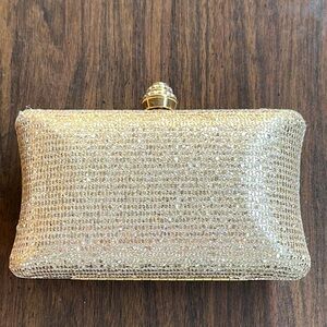 Gold clutch purse/bag. Gem studded latch. Hard shell. Black inside.